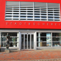 Bild vergrößern: Zu sehen ist der Eingangsbereich der Stadtbcherei, die Fassade ist in Rot gestrichen.